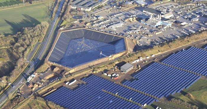 Solarthemriekraftwerk der VOJENS FJERNVARMEVÆRK im dänischen Vojens mit insgesamt 70.000 Quadratmetern Kollektorfläche und 50 MW Leistung. Links ist ein 14 Meter tiefer Wärmespeichr zu sehen, der Warmwasser für den Winter speichert. Foto: Arcon Sunmark