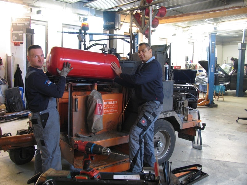 Sékou Timplan (rechts) und ein Mitarbeiter montieren in ihrer Leipziger Werkstatt einen 100-Liter-Autogas-Tank. Die Vorrichtungen dafür fertigten sie selbst. Foto: Urbansky